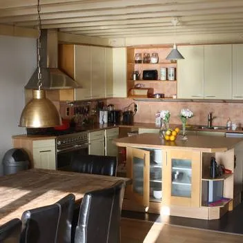 De keuken met kookunit, kookeiland en de eettafel ernaast