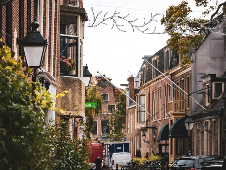 Een geplaveid straatje in de binnenstad van Leeuwarden, met bakstenen gevels en lantaarns